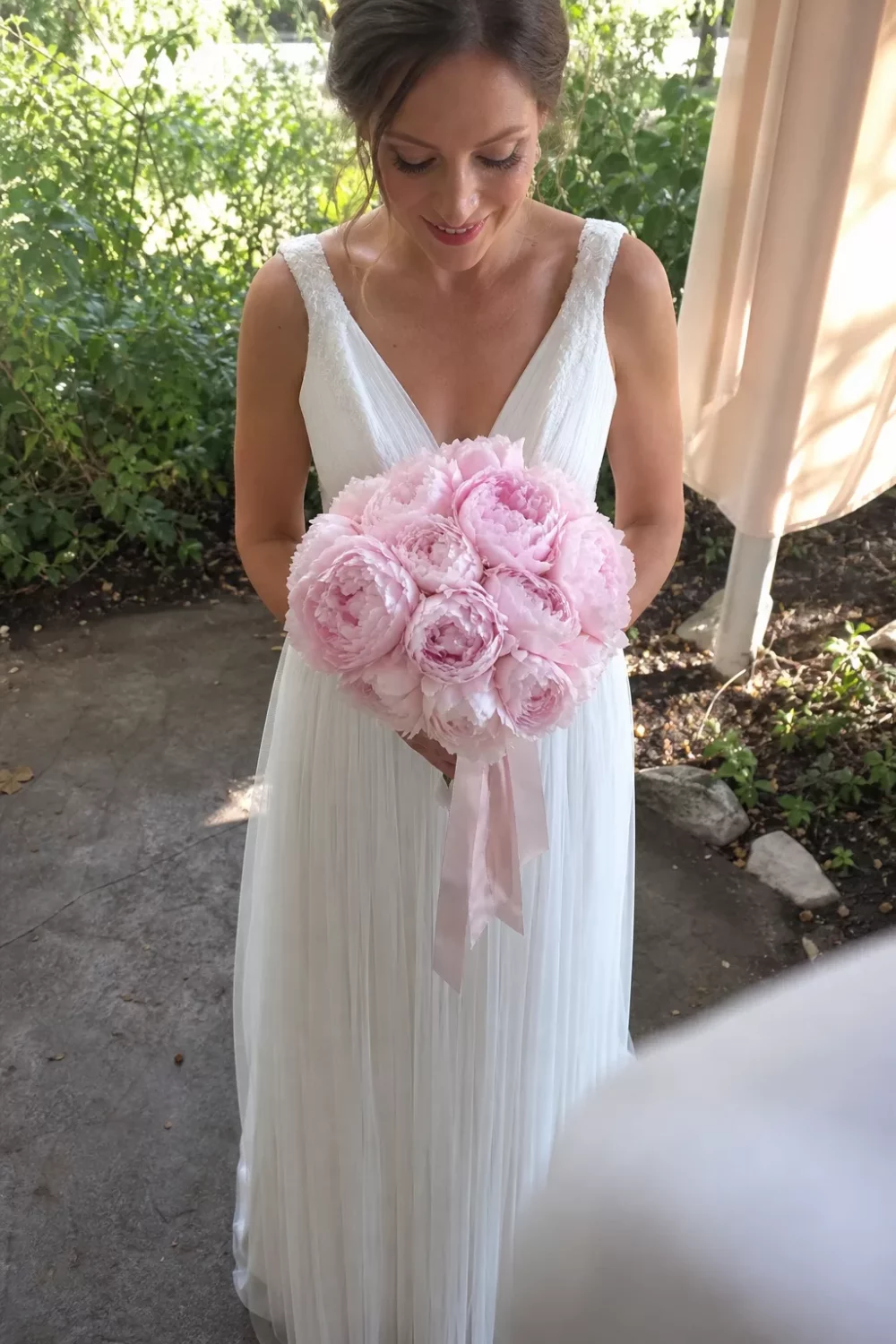 Bride holding a blush peony bouquet, a classic pick among pink wedding bouquets