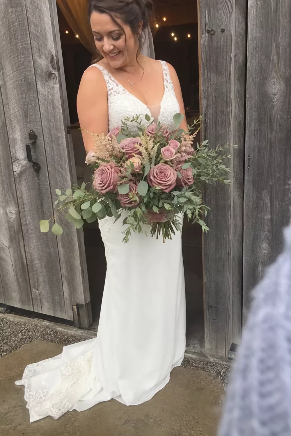 Bride holding a pink wedding bouquet of dusty rose flowers and sage greenery