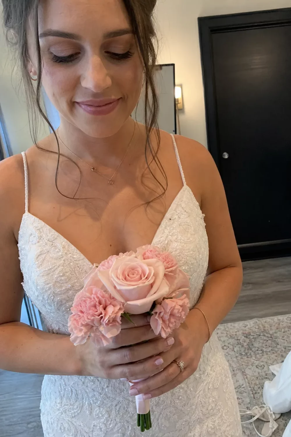 Bride holding a dusty pink rose and carnation wedding bouquet